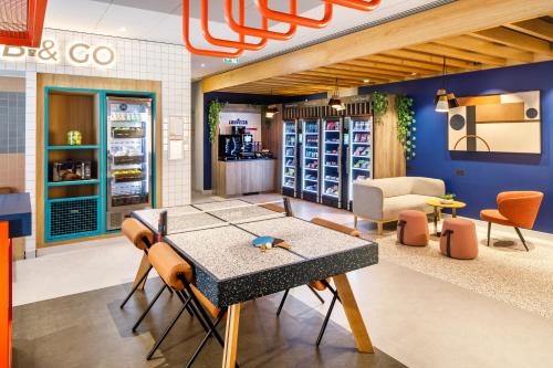 a dining room with a table and chairs in a store at ibis budget Manchester Airport T2 in Hale