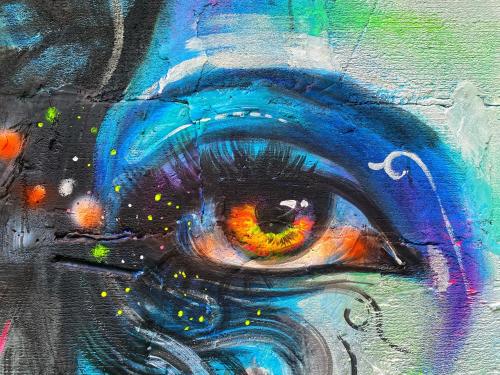 a painting of an eye on a wall at Canvas and Coffee in Kasol