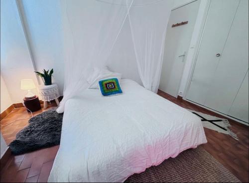 une chambre avec un lit blanc avec un oreiller dessus dans l'établissement Appartement de charme, à Avignon