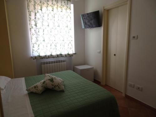 a small bedroom with a green bed with a window at Archi Di Sole in Riccò del Golfo di Spezia
