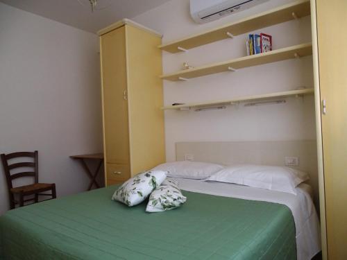 a bedroom with a green bed with two pillows on it at Archi Di Sole in Riccò del Golfo di Spezia