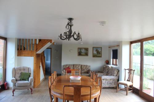 a dining room and living room with a table and chairs at Parkfields Barns Self Catering Accommodation in Buckingham