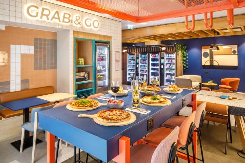 a restaurant with a long table with plates of food at ibis budget Manchester Airport T2 in Hale