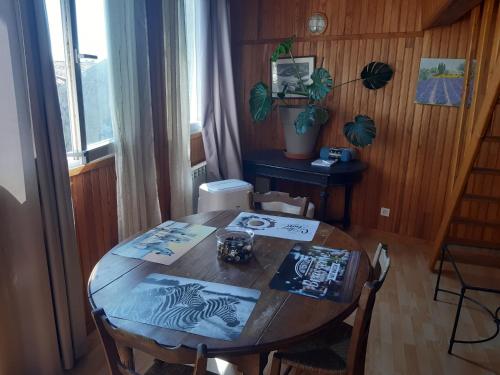 une table en bois avec des chaises et une table avec un livre. dans l'établissement ETAPE DE ST COUAT, à Saint-Couat-dʼAude