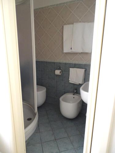 a bathroom with two sinks and a tub and a toilet at Archi Di Sole in Riccò del Golfo di Spezia