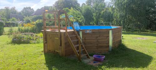 a ladder is next to a hot tub next to a wooden deck at Ferienwohnung Marienkäfer in Wulkow