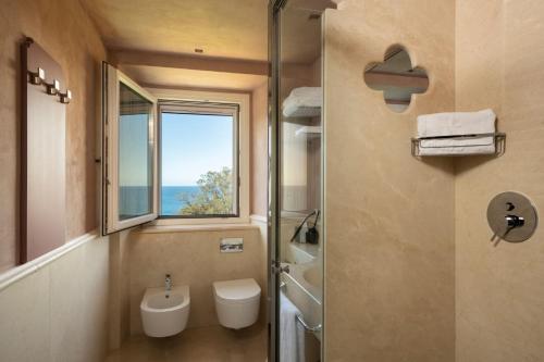 a bathroom with a shower and a toilet and a window at Villa Lattanzi in Marina Palmense