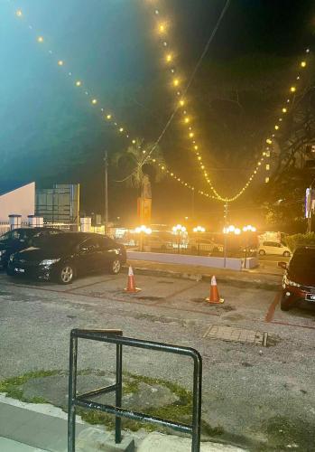 a parking lot with cars parked in a parking lot with lights at Grand Star Hotel in Batu Ferringhi