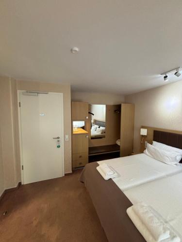 a bedroom with a large bed and a bathroom at Hotel Ortel GmbH in Besigheim