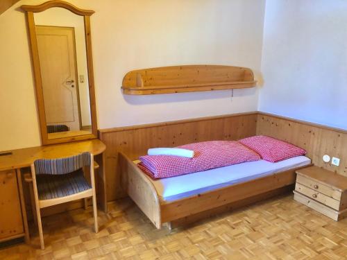 a small bedroom with a bed and a mirror at Hotel Ledererwirt in Sankt Lambrecht