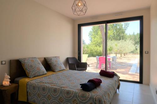 une chambre avec un lit et une grande fenêtre dans l'établissement Villa design Mazanel, piscine, vue Mont Ventoux et plaine, climatisation, à Mazan