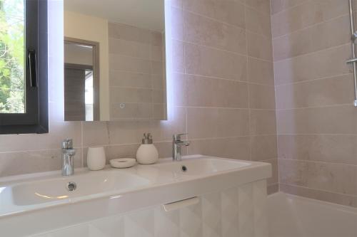une salle de bain blanche avec un lavabo et un miroir dans l'établissement Villa design Mazanel, piscine, vue Mont Ventoux et plaine, climatisation, à Mazan