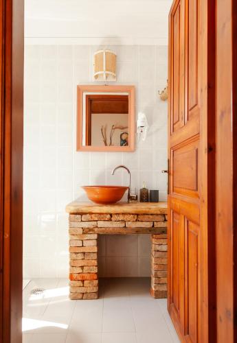 a bathroom with a wooden sink and a mirror at AMNISIADES APARTMENTS in Karteros
