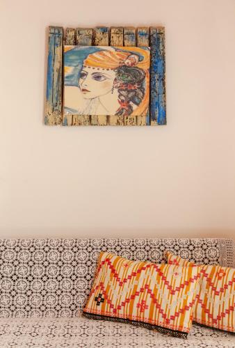 a painting and two pillows sitting on a couch at AMNISIADES APARTMENTS in Karteros