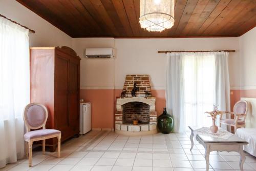 a living room with a fireplace and a table and chairs at AMNISIADES APARTMENTS in Karteros