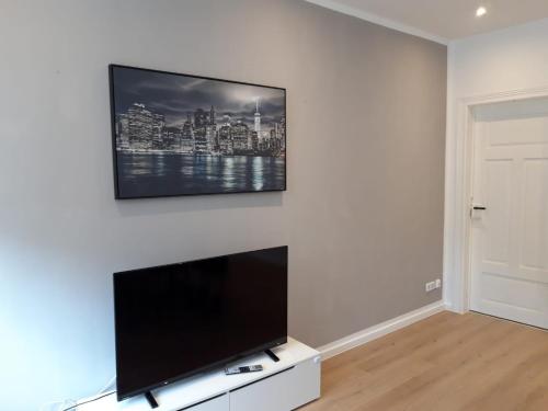 a living room with a flat screen tv on a wall at Seyfarthrooms - Crimmitschau 5 - zentrale Lage, 2 Schlafzimmer, voll ausgestattet in Crimmitschau