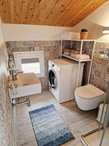 a bathroom with a washing machine and a washer at Casa del Sole Marzamemi Borgo 84 in Marzamemi
