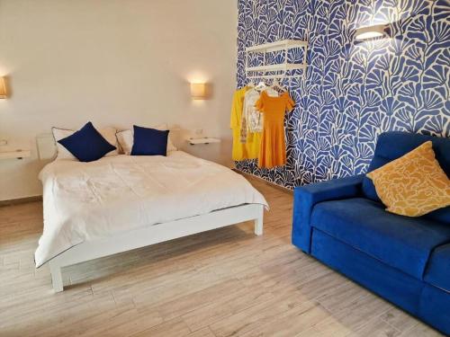 a bedroom with a bed and a blue couch at Case del Sole Marzamemi Borgo 84 in Marzamemi
