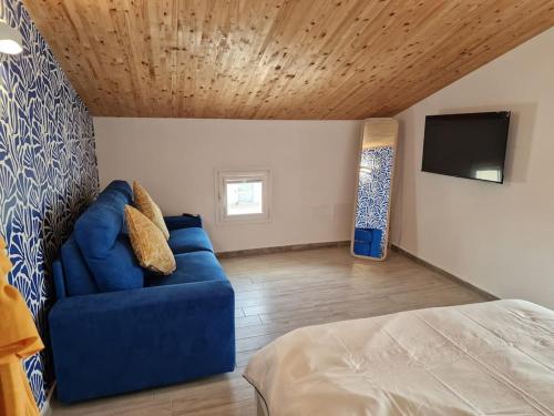 a living room with a blue couch and a tv at Case del Sole Marzamemi Borgo 84 in Marzamemi
