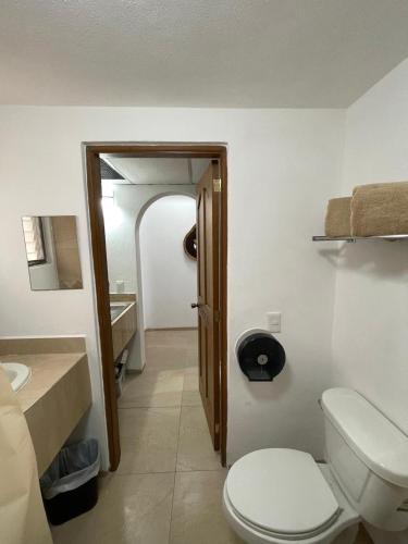 a bathroom with a toilet and a sink at Palma Real vista al mar in Manzanillo