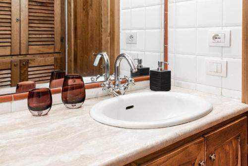 a bathroom with a sink and two glasses on a counter at Magnifica residenza a Manciano - Terme di Saturnia in Manciano