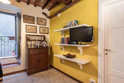 a living room with a tv on a yellow wall at Magnifica residenza a Manciano - Terme di Saturnia in Manciano