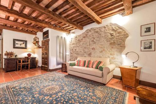 a living room with a couch and a stone wall at Magnifica residenza a Manciano - Terme di Saturnia in Manciano