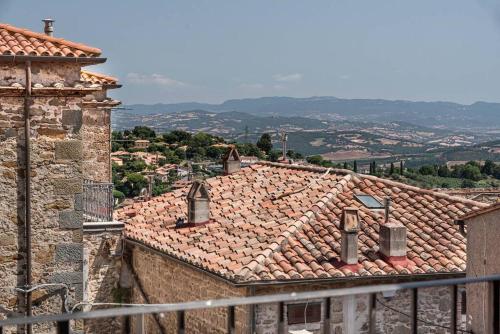 a view of roofs of buildings with mountains in the background at Magnifica residenza a Manciano - Terme di Saturnia in Manciano