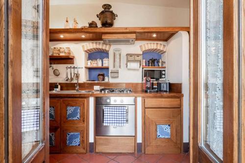 a kitchen with wooden cabinets and a stove top oven at Magnifica residenza a Manciano - Terme di Saturnia in Manciano