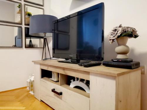 una TV a schermo piatto su un centro di intrattenimento in legno di Stan na dan Bijeljina centar a Bijeljina