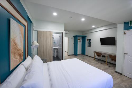 a bedroom with a white bed and a desk at SkyLink Homes in Bangkok
