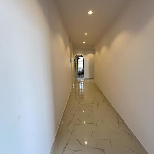 an empty hallway with marble floors and a window at The Red Sea Apartment شقة البحر الأحمر in Jeddah
