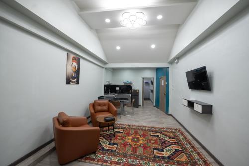 a living room with chairs and a table and a rug at SkyLink Homes in Bangkok