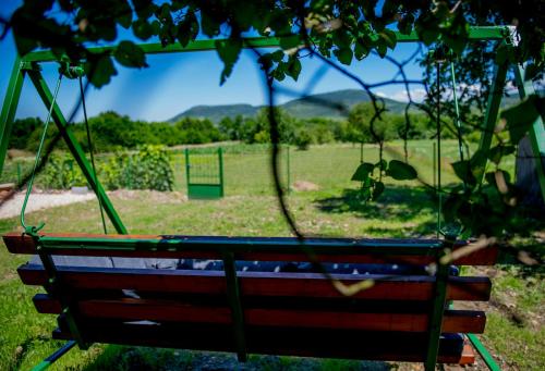 a swing in a field with a view of a field at Orgona Vendégház Golop in Golop