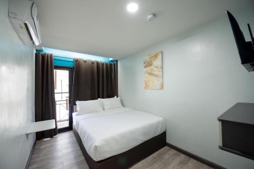 a bedroom with a white bed and a window at SkyLink Homes in Bangkok