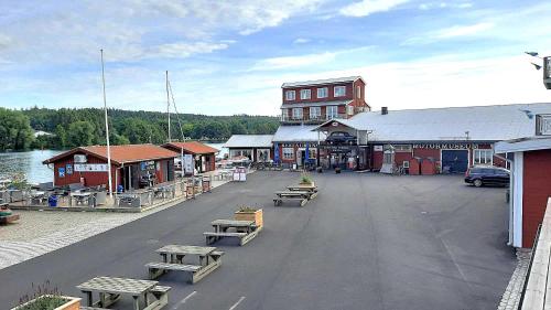 a town with a dock with benches and a building at Boende - Stuga nära naturen, 3 km till Motala centrum, elbilsladdning finns på tomten - privat värd in Motala