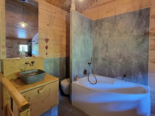 une salle de bain avec une baignoire, un lavabo et des toilettes dans l'établissement Duplex rénové 3P+cabine 6 pers, balcon, vue Mont Blanc - FR-1-181-2732, à La Plagne Tarentaise