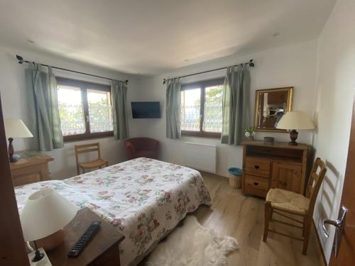 une chambre avec un lit et un bureau et deux fenêtres dans l'établissement Appartement 5 pers, centre Cernix, piste & commerces, animaux admis, parking, balcon - FR-1-733-148, à Crest-Voland