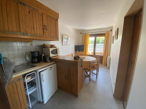 - une cuisine avec des placards en bois et une table à manger dans l'établissement Appartement 5 pers, centre Cernix, piste & commerces, animaux admis, parking, balcon - FR-1-733-148, à Crest-Voland