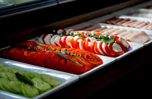 a buffet of hot dogs and vegetables on trays at Hotel Eureka in Sopot