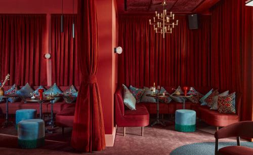 a dining room with red curtains and tables and chairs at Beckett Locke in Dublin