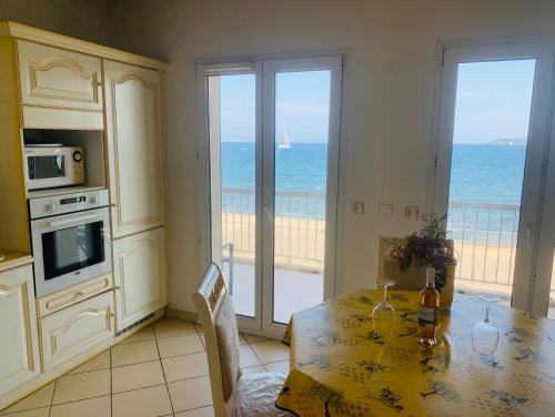 une cuisine avec une table et une vue sur l'océan dans l'établissement Le Latania, à Sainte-Maxime