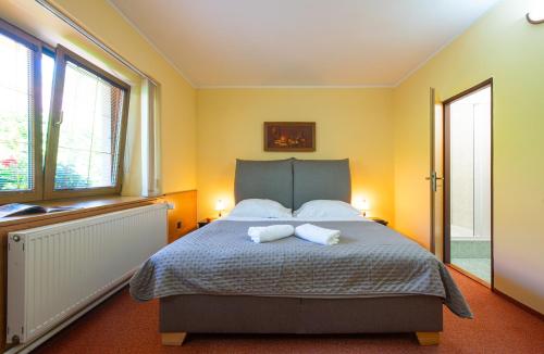 a bedroom with a bed with two towels on it at Penzión Max Kežmarok in Kežmarok