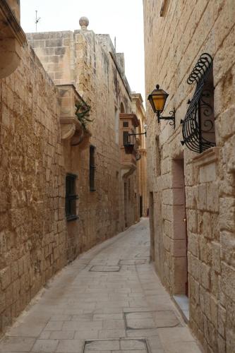 an alley with stone buildings and a street light at Mosta Central City Residences by 360 Estates in Mosta