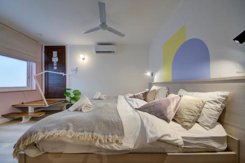 a bedroom with a large bed and a ceiling fan at Mosta Central City Residences by 360 Estates in Mosta
