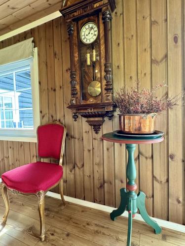 a table with a chair and a clock on a wall at Cozy, well-equipped and family-friendly cabin in Geilo in Geilo
