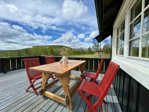 a wooden table and four chairs on a deck at Cozy, well-equipped and family-friendly cabin in Geilo in Geilo