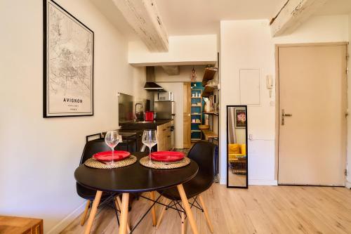 une cuisine et une salle à manger avec une table et des chaises dans l'établissement Appartement en plein coeur historique et animé, à Avignon