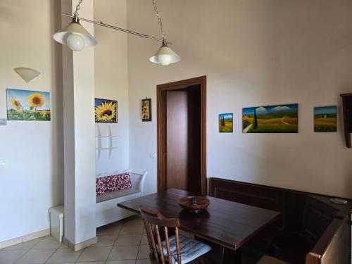 a dining room with a table and some paintings on the wall at Villetta Pia in Contignano