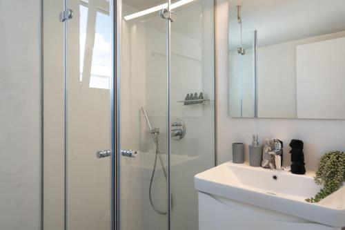 a bathroom with a glass shower and a sink at Revived Urban Charm - 1BR in Athens